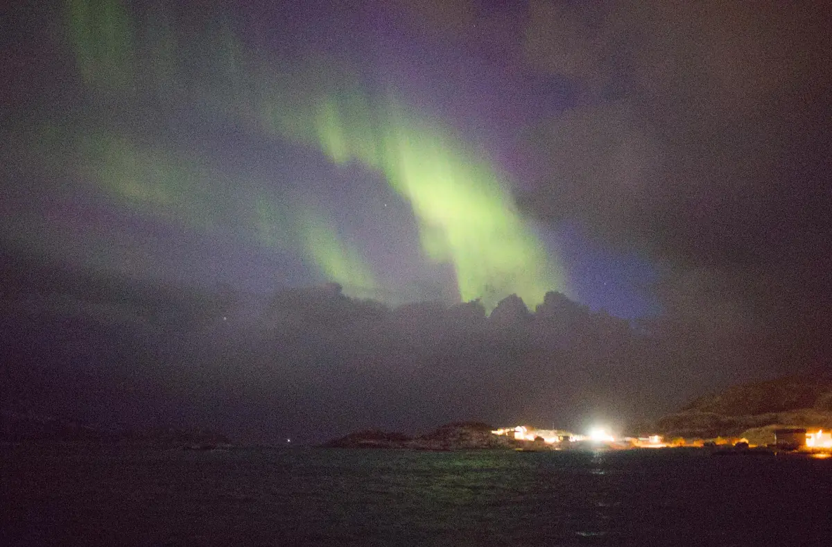 Northern lights over the lights of Sommarøy