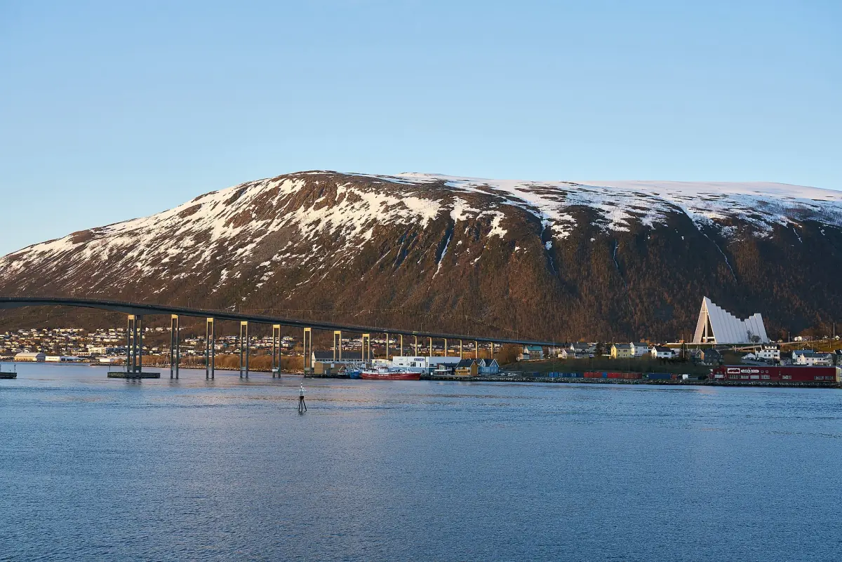 Die Tromsø-Brücke und die Eismeerkathedrale vor verschneiten Bergen